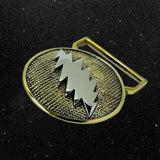 Gold belt buckle with a central emblem on a black background